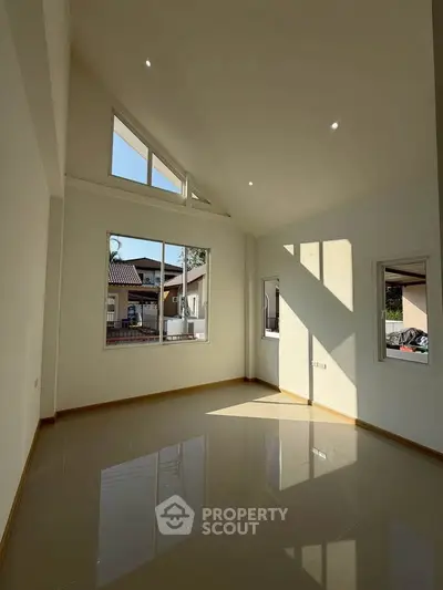 Spacious room with high ceilings and large windows for natural light