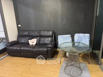 Modern living room with leather sofa and stylish glass table in a cozy apartment setting.