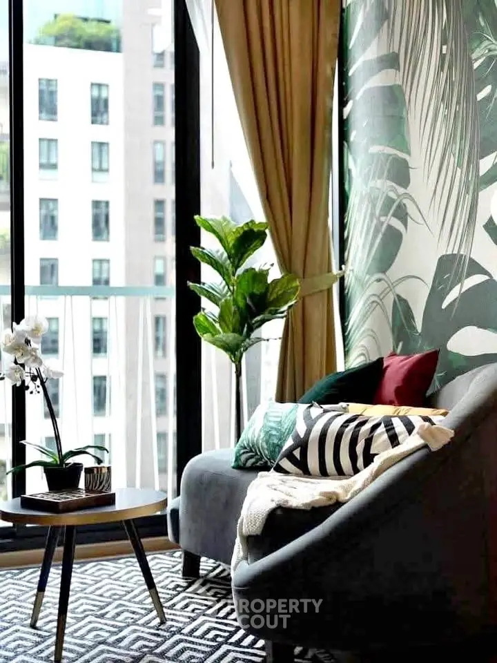 Stylish living room with modern decor, large windows, and lush greenery view.