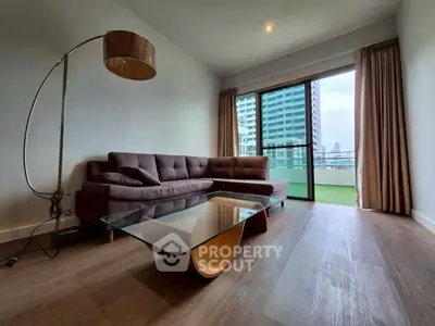 Modern living room with sleek furniture and city view balcony.