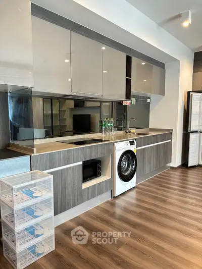 Modern kitchen with sleek cabinetry and built-in washing machine