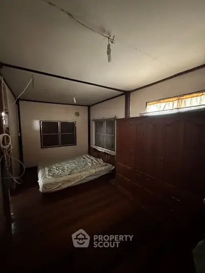 Cozy bedroom with wooden flooring and large wardrobe, perfect for restful nights.