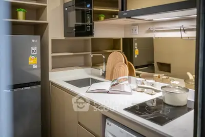 Modern kitchen with sleek appliances and open layout, featuring a built-in microwave and induction cooktop.