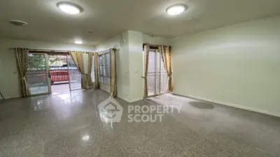 Spacious living room with large windows and balcony access, perfect for natural light and open living.