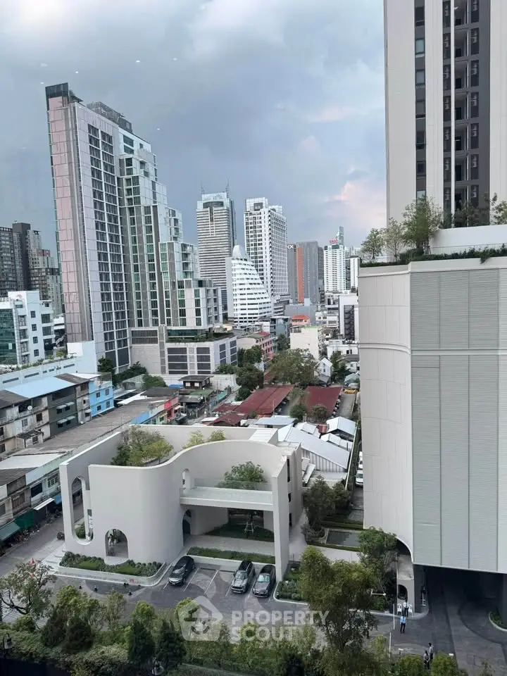 Stunning cityscape view from high-rise building with modern architecture and lush greenery.