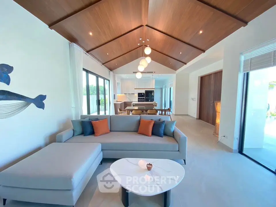 Luxurious open-plan living room with modern decor and vaulted wooden ceiling
