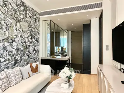 Modern living room with stylish decor and open layout, featuring a cozy sofa and elegant marble accents.