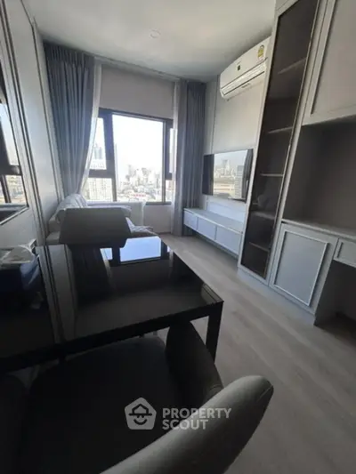 Modern living room with city view, sleek furniture, and ample natural light.