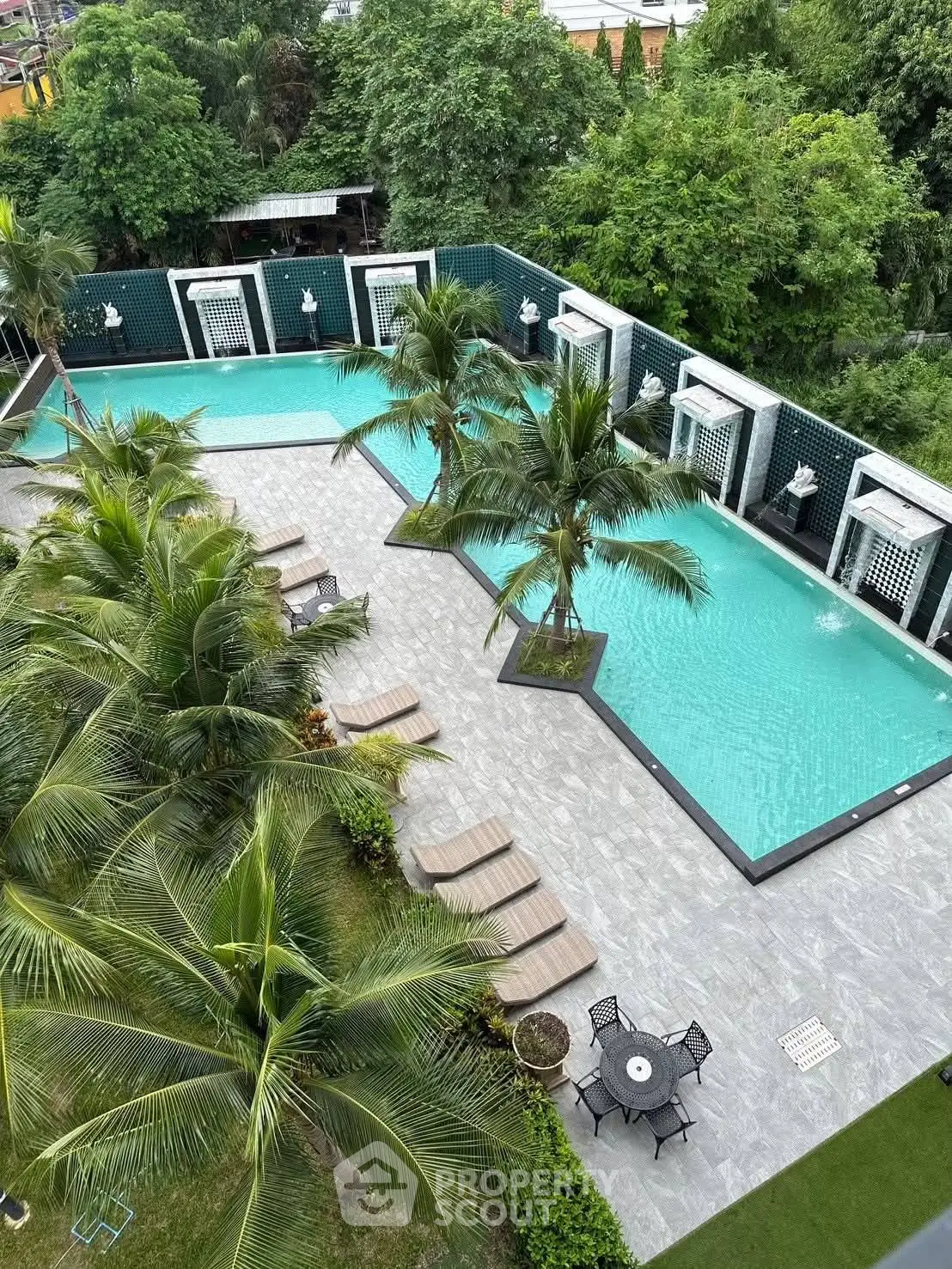 Luxurious outdoor pool area with palm trees and sun loungers, perfect for relaxation and leisure.