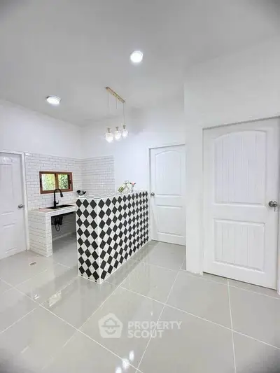 Modern kitchen with stylish black and white checkered backsplash and sleek white cabinetry.