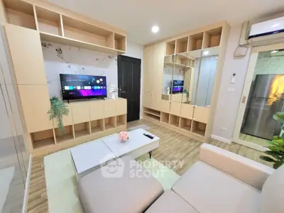 Modern living room with stylish furniture and built-in storage, featuring a sleek TV setup.