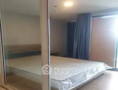 Spacious bedroom with large window and modern decor in a stylish apartment.