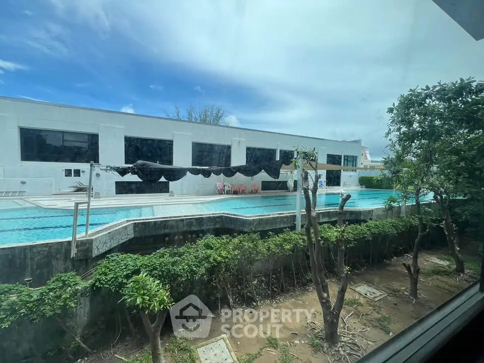 Luxurious poolside view with modern architecture and lush greenery, perfect for relaxation and leisure.