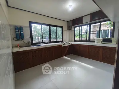 Spacious kitchen with ample natural light and wooden cabinetry in a modern home.