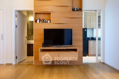 Modern living room with wooden TV wall unit and open kitchen view