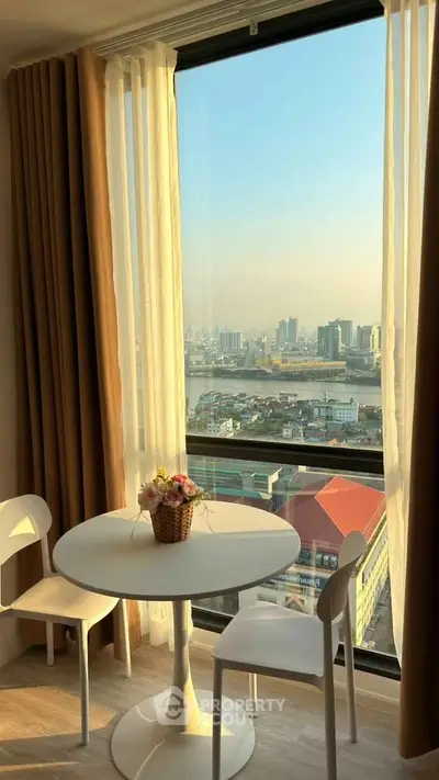Charming dining nook with stunning city view from high-rise apartment window.