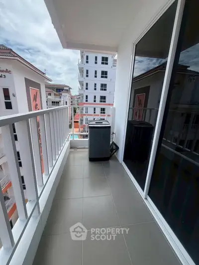 Spacious balcony with modern washing machine and city view in a high-rise apartment.