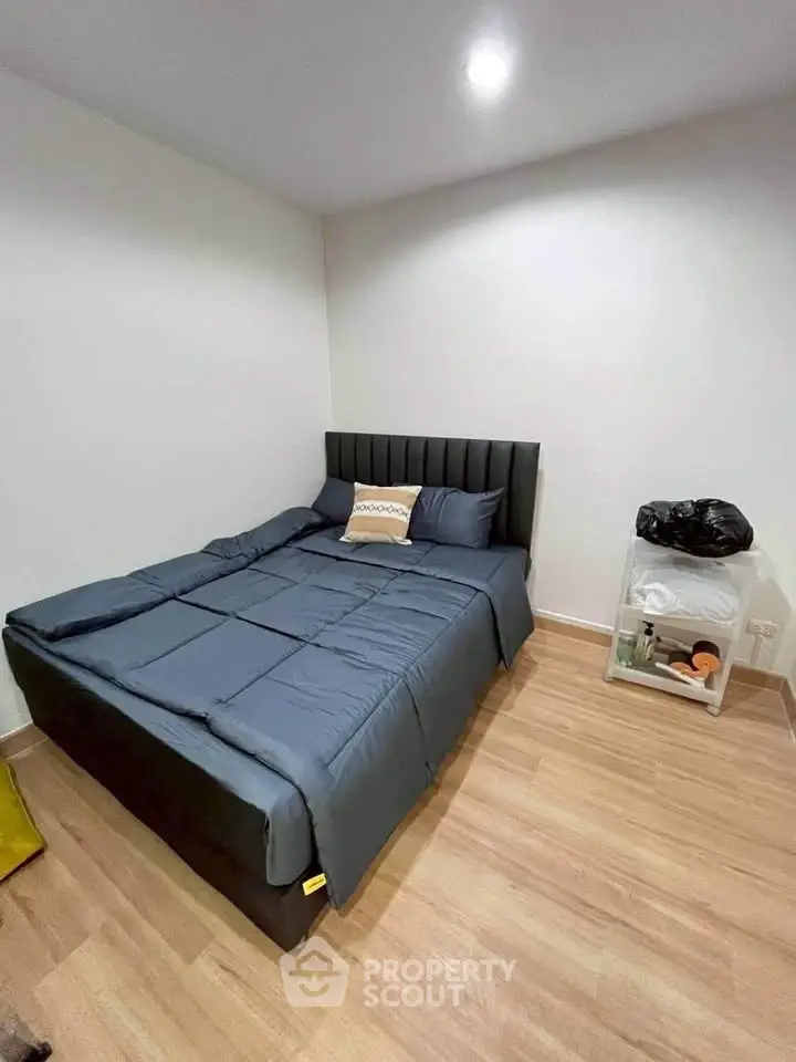 Cozy bedroom with modern bed and wooden flooring, perfect for relaxation.