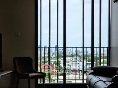 Modern apartment with stunning city view through large windows and cozy seating area.