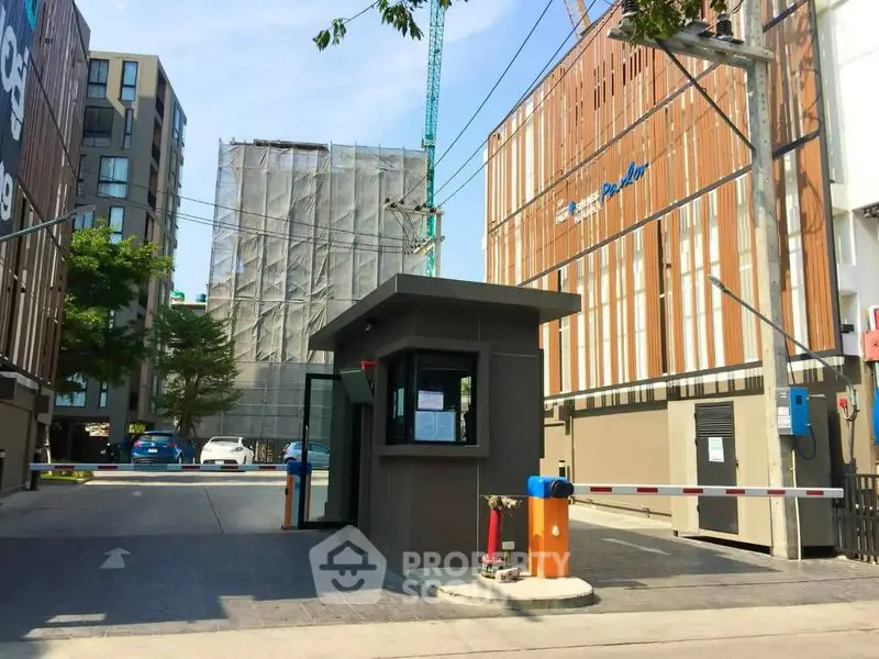 Modern gated entrance with security booth in urban residential complex