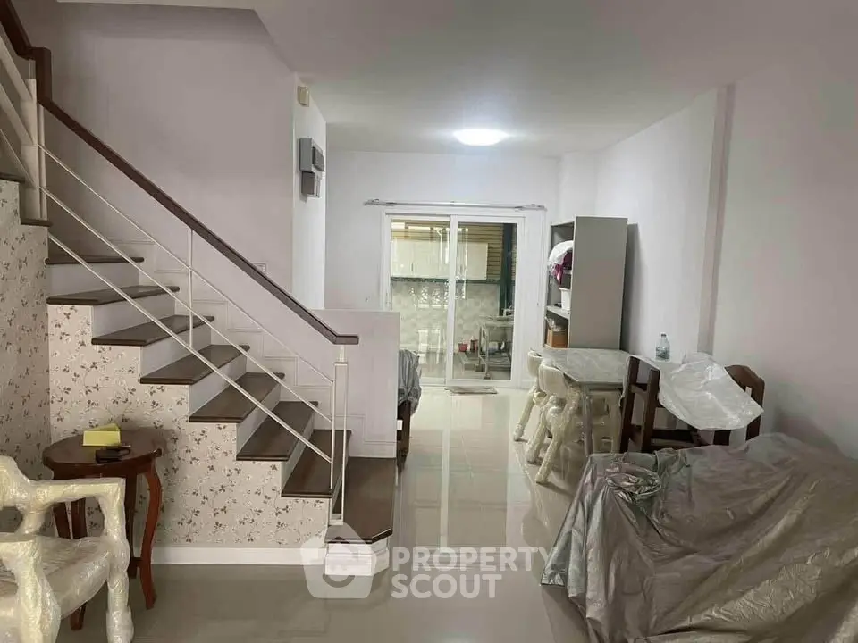 Spacious living room with modern staircase and open layout kitchen