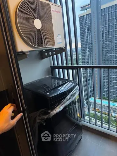 Compact balcony with washing machine and city view in modern high-rise apartment.