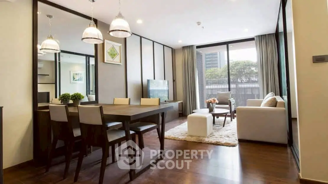 Modern living room with elegant dining area and large windows offering natural light.