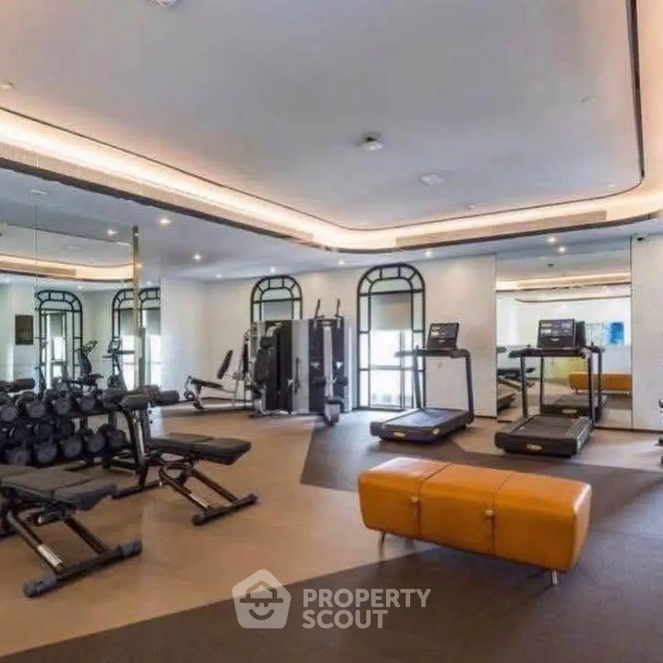 Luxurious gym with modern equipment and stylish design in upscale residential building.