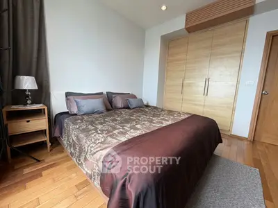 Spacious bedroom with elegant wooden flooring and modern furnishings