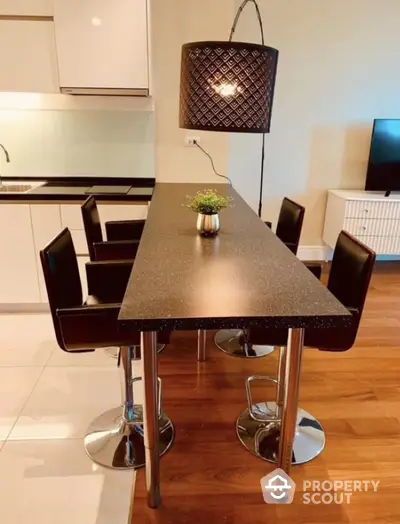 Modern kitchen with sleek black countertop and stylish bar stools