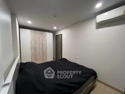 Modern bedroom with sleek design, featuring a comfortable bed, built-in wardrobe, and air conditioning.