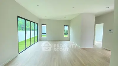 Spacious empty living room with large windows and wooden flooring