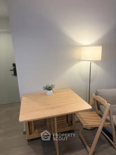 Cozy living room corner with wooden table, chair, and floor lamp for a warm ambiance.