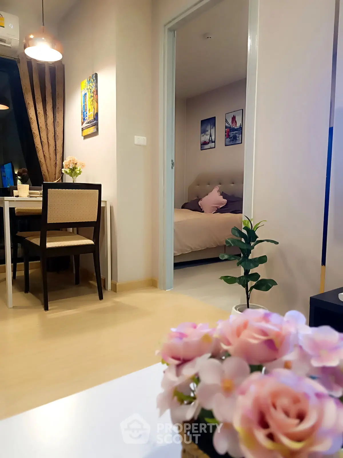 Cozy apartment interior with dining area and bedroom view, featuring elegant decor and soft lighting.