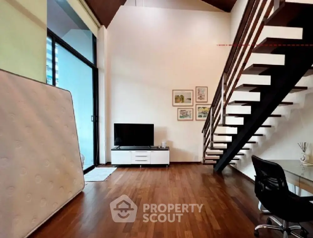 Spacious modern living room with wooden flooring and stylish staircase