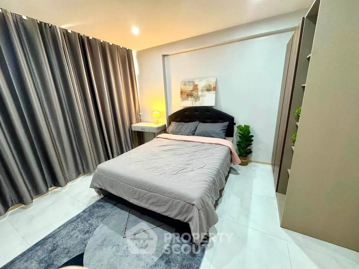 Modern bedroom with stylish decor, cozy bed, and elegant curtains in a contemporary apartment.