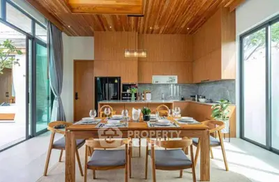 Modern kitchen with wooden cabinetry and dining area in open layout, featuring elegant table setting and natural light.