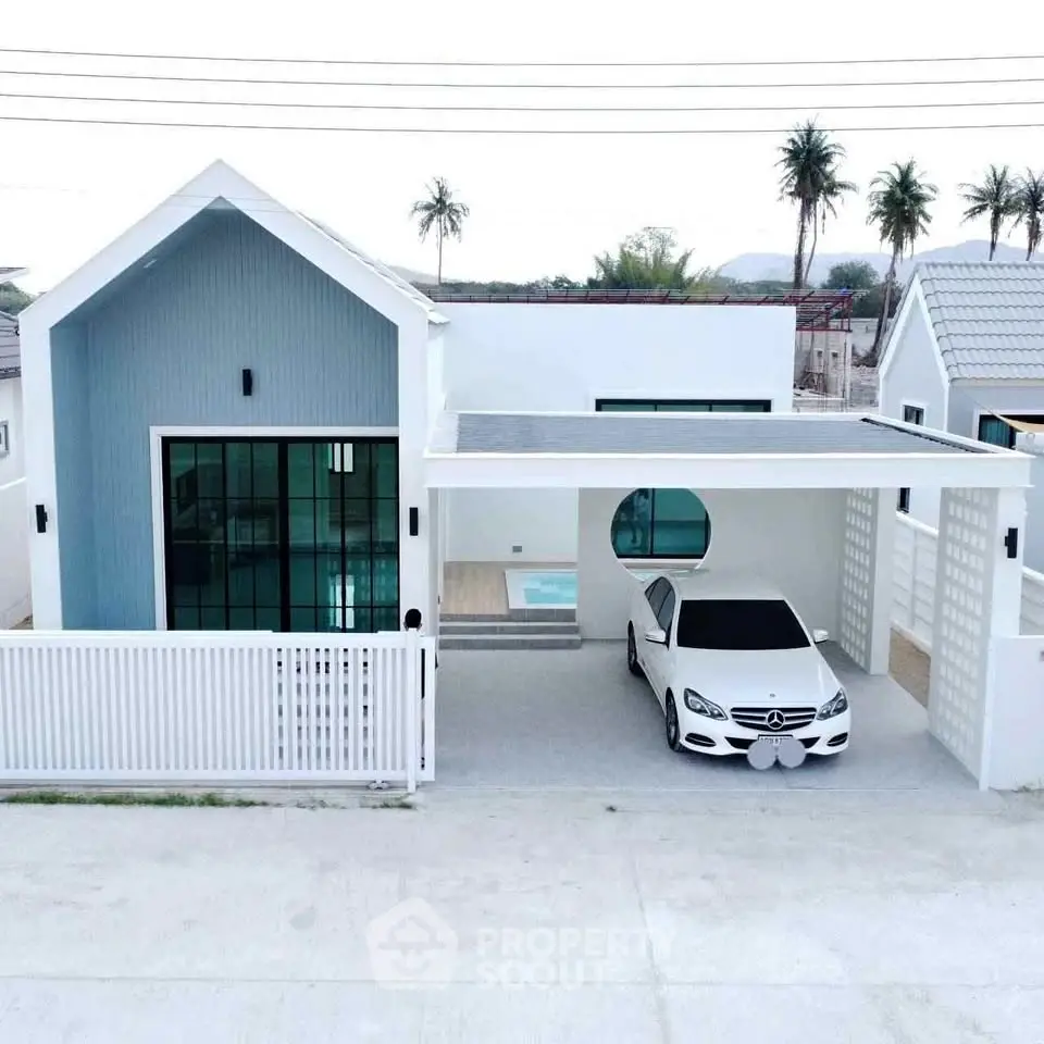 Modern white house with carport and sleek design, featuring a spacious driveway and minimalist architecture.