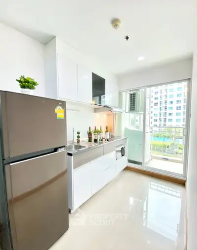 Modern kitchen with sleek appliances and balcony view in a bright apartment.
