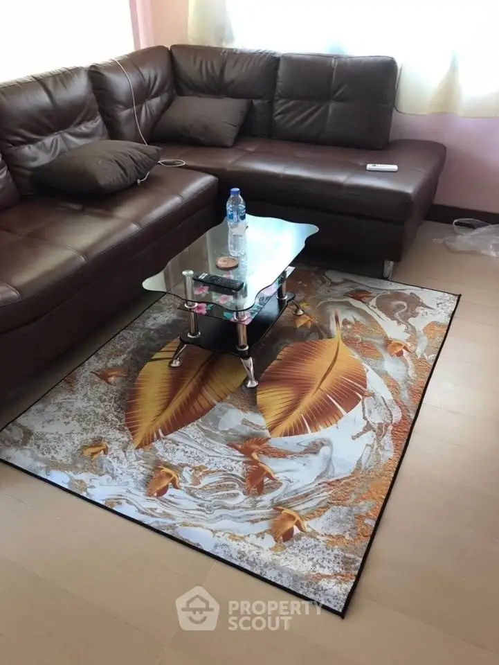 Cozy living room with stylish brown leather sofa and artistic rug, perfect for relaxation.
