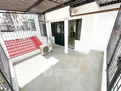 Spacious balcony with secure metal grating and air conditioning unit