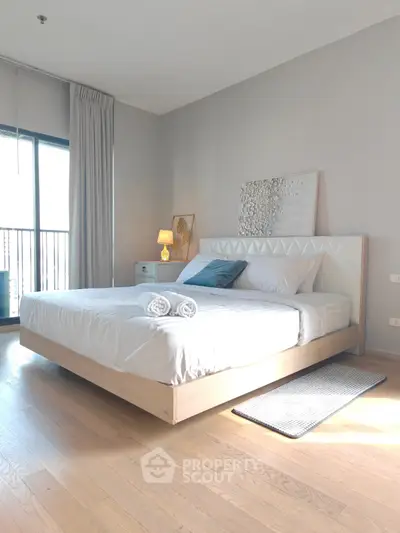 Modern bedroom with stylish decor and natural light, featuring a cozy bed and elegant furnishings.