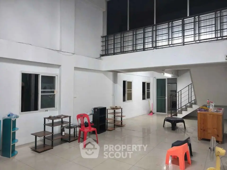 Spacious open-plan living area with modern staircase and ample natural light.