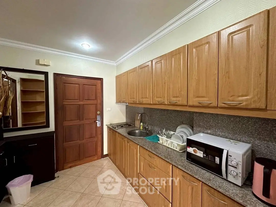 Spacious kitchen with wooden cabinets and modern appliances, perfect for culinary enthusiasts.