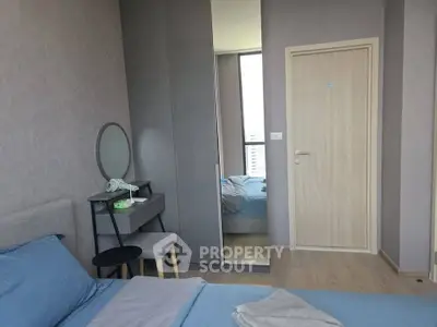 Modern bedroom with stylish decor and large mirror reflecting natural light.