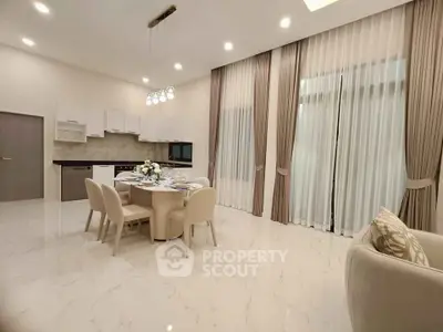 Luxurious open-plan living room with elegant dining area and modern kitchen, featuring high ceilings and floor-to-ceiling curtains.