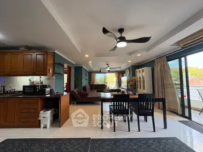 Spacious open-plan living room with modern kitchen and large windows offering scenic views.