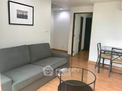 Cozy living room with modern furniture and wooden flooring in a stylish apartment.
