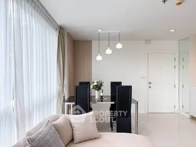 Elegant modern living room with dining area, featuring sleek furniture and soft lighting.