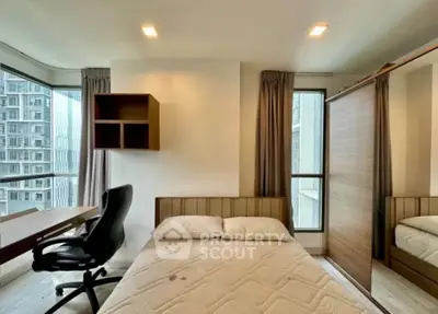 Modern bedroom with large window and study area in high-rise apartment